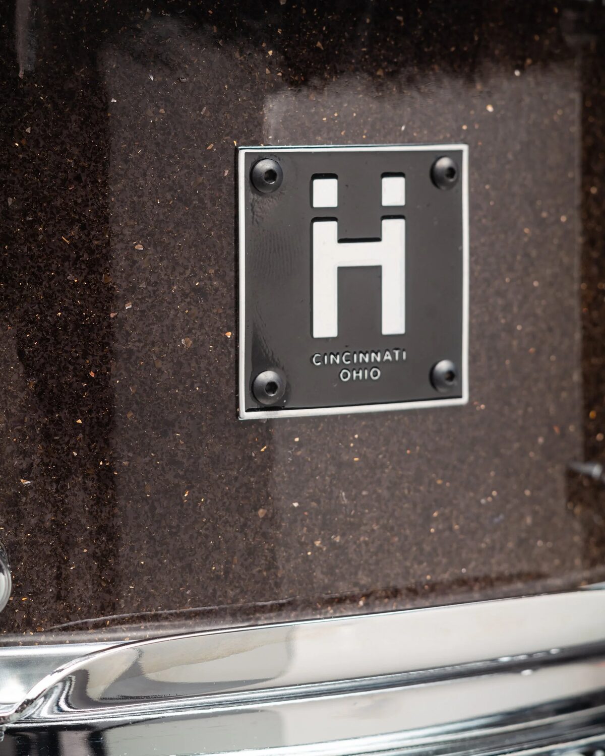 The HandShake Ḧ badge on a dark sparkle shell